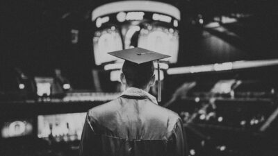 man in academic dress wearing mortar cap