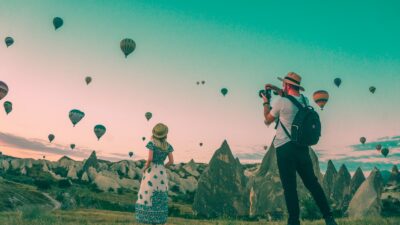 man taking photo of hot air balloons