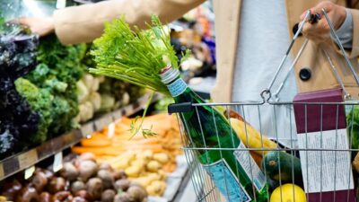 woman in white coat holding food and beverage