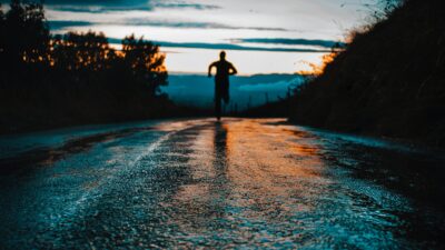 silhouette photo of a person running on road