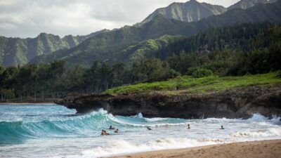 people swimming near shore with waves during daytime