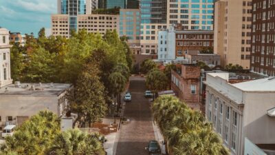 cars parked on parking lot near high rise buildings during daytime