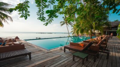 brown wooden table and chairs on brown wooden deck near body of water during daytime